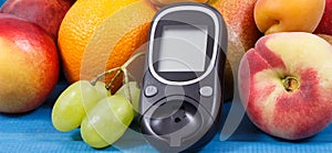 Glucose meter and fresh natural fruits containing vitamins for healthy lifestyles of diabetics