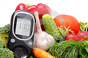 Glucose meter and fresh vegetables photo