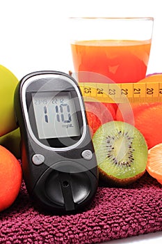 Glucose meter, fruits, tape measure and glass of juice