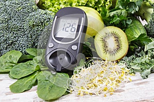 Glucose meter with fruits, vegetables and sprouts. Checking sugar level and healthy lifestyles