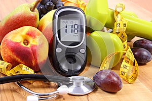 Glucose meter with medical stethoscope, fruits and dumbbells for using in fitness