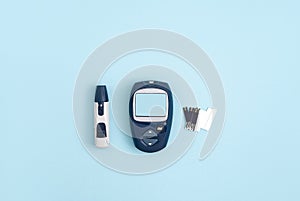 Glucose meter and pen on blue background, top view. Metabolic syndrome concept