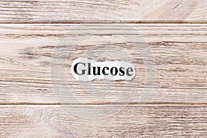 GLUCOSE of the word on paper. concept. Words of GLUCOSE on a wooden background