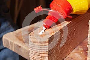 Gluing of wooden products,worker put glue on a wooden furniture plank