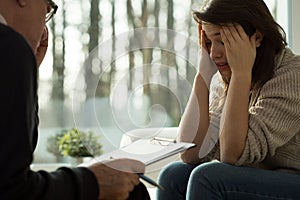 Glum girl during psychotherapy session photo