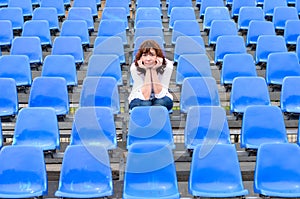 Glum woman sitting in spectator seating photo