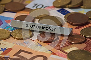 glut of money - the word was printed on a metal bar. the metal bar was placed on several banknotes