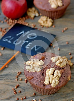 Gluten free muffins from buckwheat flour, apple, cinemon and walnuts on brown wooden background with index card with text no glute