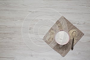 Gluten free rice flour in a pink bowl over white wooden background,  overhead view. Flat lay, top view, from above. Copy space