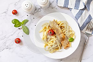 Gluten-free spaghetti pasta with grilled salmon in cream cheese on a marble background. View from above