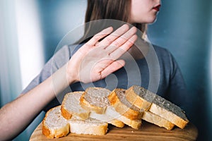 Gluten intolerance concept. Young girl refuses to eat white bread - shallow depth of field photo