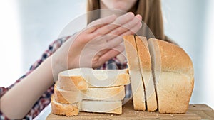 Gluten intolerance concept. Young girl refuses to eat white bread - shallow depth of field