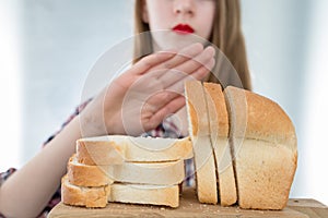 Gluten intolerance concept. Young girl refuses to eat white bread - shallow depth of field