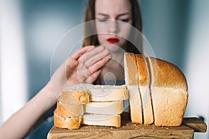 Gluten intolerance and diet concept. Young girl refuses to eat bread