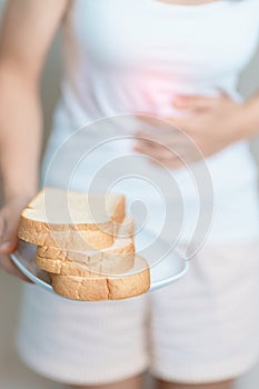 Gluten intolerance, Gluten free and celiac disease or wheat allergy concept. woman hold Bread and having abdominal pain after eat