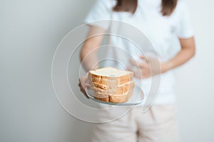 Gluten intolerance, Gluten free and celiac disease or wheat allergy concept. woman hold Bread and having abdominal pain after eat