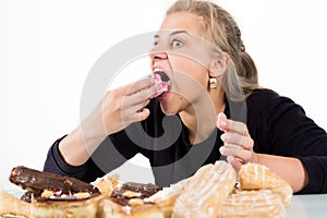 Glutton woman eating cupcakes with frenzy after long diet