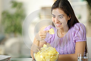 Glutton woman eating potato chips eagerly