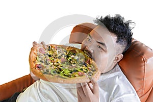 Gluttony fat man eating big pizza on the sofa photo