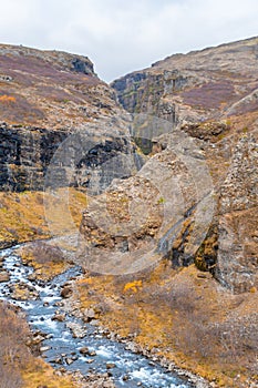 Glymur waterfall in Iceland gorge behind fall cutting through autumn landscape