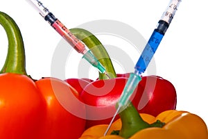 GMO food concept. Syringes are stuck in vegetables with chemical additives. Injections into fruits and vegetables.