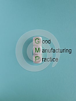 GMP, good manufacturing practice symbol. Concept words GMP, good manufacturing practice on cubes on a beautiful blue background.