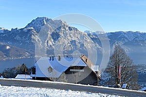 The Gmundnerberg Haus on the Gmundnerberg in winter with the Traunstein and Traunsee in the background, Austria, Europe