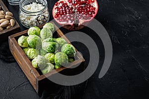 Gnarly garlic brussels ingredients, on black textured background with space for text