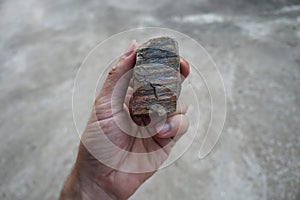 Gneiss rock specimen in a hand.