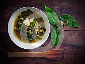 Gnetum gnemon or melinjo leaves and fish in yellow hot and sour soup