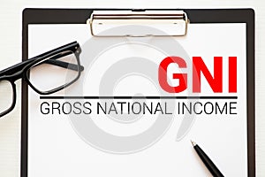 GNI- Gross National Income acronym written in notebook on wooden background