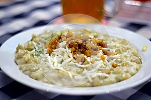 Gnocchi with bacon white plate on table in restaurant