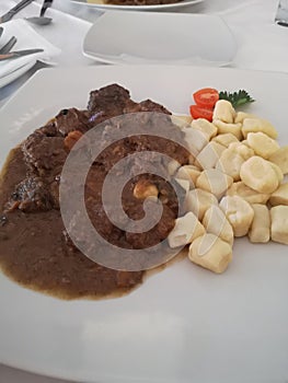 Gnocchi and Boar Stew Served on White Plate