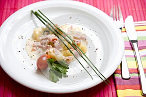 Gnocchi with cream sauce, tomatoes, parsley, and chive