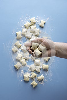 Gnocchi dumplings uncooked. Cheese gnocchi in hand