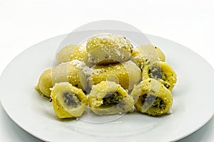 Gnocchi ripieni dumplings with Pecorino Romano cheese in a white dish.