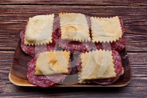 Italian Gnocco Fritto with salami on rustic wooden table. photo