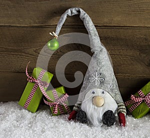 Gnom santa with green and red christmas presents in rustic count
