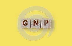 GNP Gross Domestic Product word made with wooden blocks on yellow background