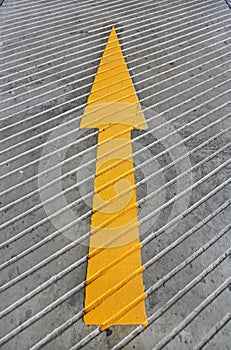 Go ahead arrow. Yellow Arrow signs as road markings. Arrow sign on slope floor at park building