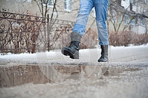 Go army boots through puddles in the city, black lace-up boots and wet weather, trekking shoes in the city, rain, snow, and hail i