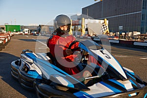 Go-cart racer moving fast on open air motor racing track