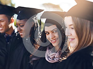 Go confidently in the direction of your dreams. Portrait of a group of students standing in a line on graduation day.