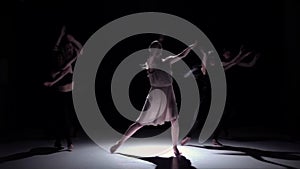 Go on contemporary dance of five dancers on black, shadow, slow motion