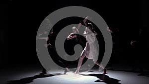 Go on contemporary dance performance of five dancers on black, shadow, slow motion