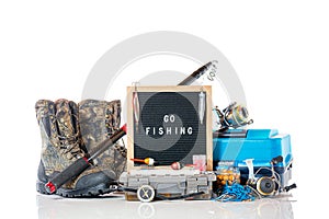 Go fishing concept. Boxes, rod with reel, reels, fishing boots, floats, compass and black letterboard with words go fishing and