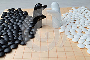 Go game pieces and two black and white figures