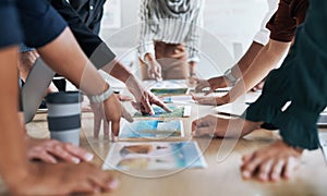 Go getters get hands on. Cropped shot of a group of businesspeople discussing paperwork during a meeting in a modern