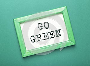 Go Green inscription in frame over green eco background