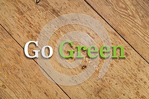 `Go green` text on a wooden background.